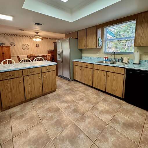 Enjoy cooking in this spacious kitchen featuring marble-style countertops, a double sink with a Enjoy cooking in this spacious kitchen featuring marble-style countertops, a double sink with a