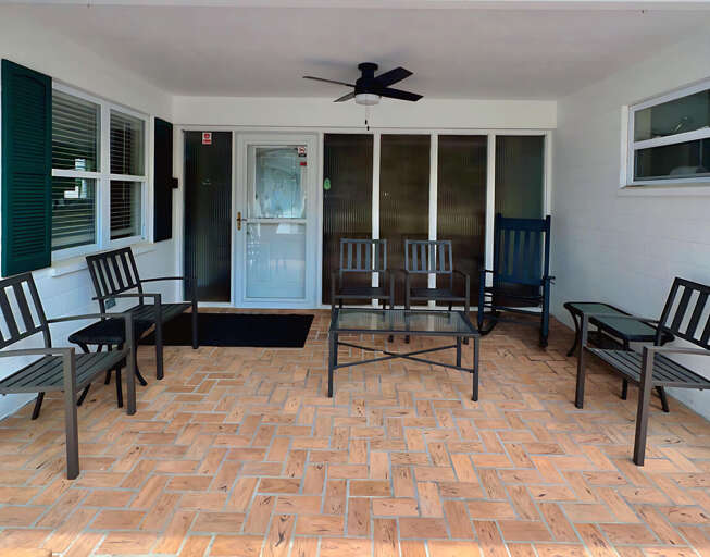 Kick back on the covered patio with plenty of seating, a ceiling fan for comfort, and a cozy brick floor — perfect for morning coffee or evening conversations in the fresh air! Kick back on the covered patio with plenty of seating, a ceiling fan for comfort, and a cozy brick floor — perfect for morning coffee or evening conversations in the fresh air!