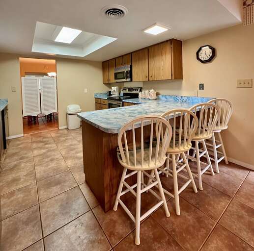 Spacious kitchen with a large marble-style island and bar seating for four — perfect for morning Spacious kitchen with a large marble-style island and bar seating for four — perfect for morning
