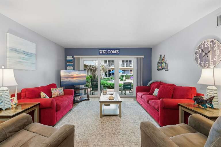 Unwind in this bright beach condo featuring comfortable seating, coastal décor, and a private patio