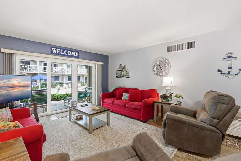 Unwind in this bright beach condo living area featuring plush seating, coastal décor, and private