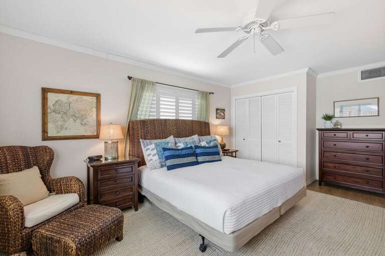 Relax in this spacious coastal king bedroom featuring beach-inspired décor, comfortable seating, and a peaceful atmosphere. The perfect beach stay retreat after a fun day by the shore.