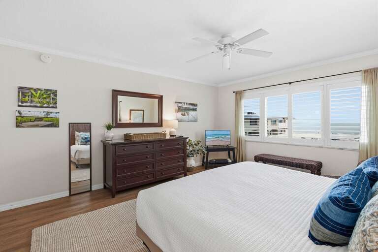 Wake up to ocean views in this bright coastal king bedroom featuring comfortable furnishings, beach-inspired décor, and a relaxing atmosphere perfect for your next beach stay.