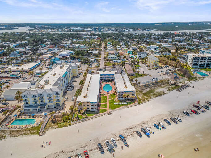Discover the perfect beach stay from above—this oceanfront property offers direct beach access, a