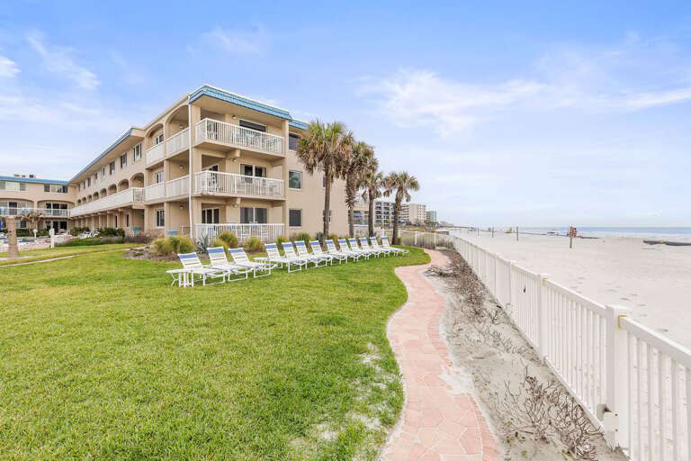 Experience the ultimate beach stay with oceanfront lawn seating, swaying palms, and direct beach access. Relax on lounge chairs or stroll the sandy shoreline just steps from your coastal getaway.