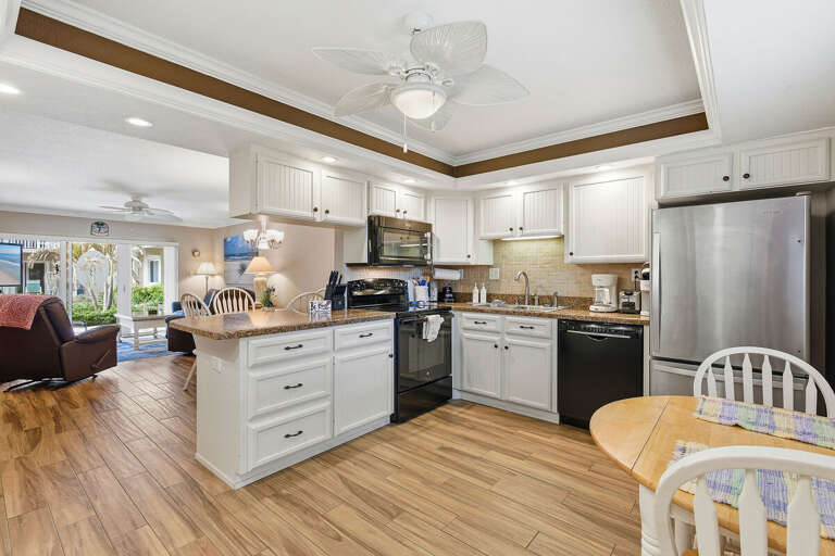 Fully equipped kitchen with modern appliances, breakfast bar, and open dining area. Perfect for your