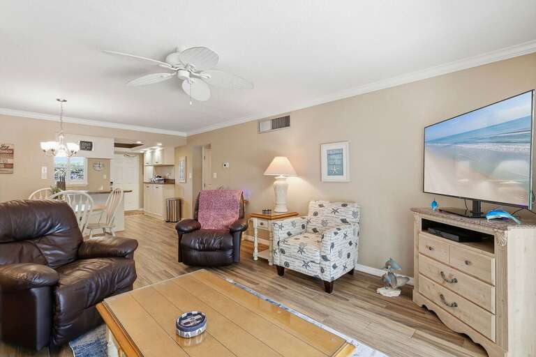 Unwind in this open beach stay living area with cozy seating, coastal décor, and TV. The spacious