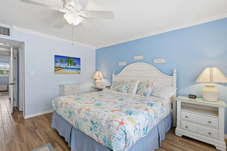 Unwind in this serene beach stay bedroom featuring a comfy bed, soft coastal décor, and calming blue tones. Perfect for restful nights after a sun-filled day by the ocean.