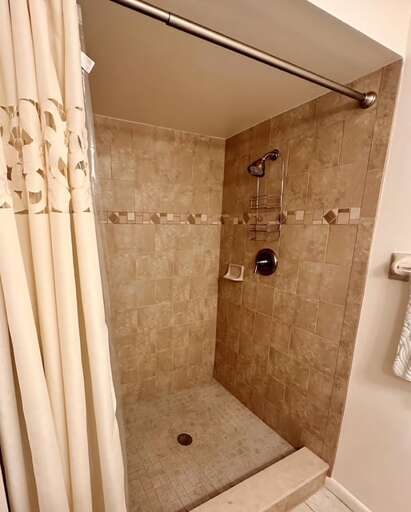 Refresh after a day at the beach in this modern walk-in shower. Featuring elegant tile and spa-like touches, it's the perfect retreat to rinse off and relax during your coastal getaway.
