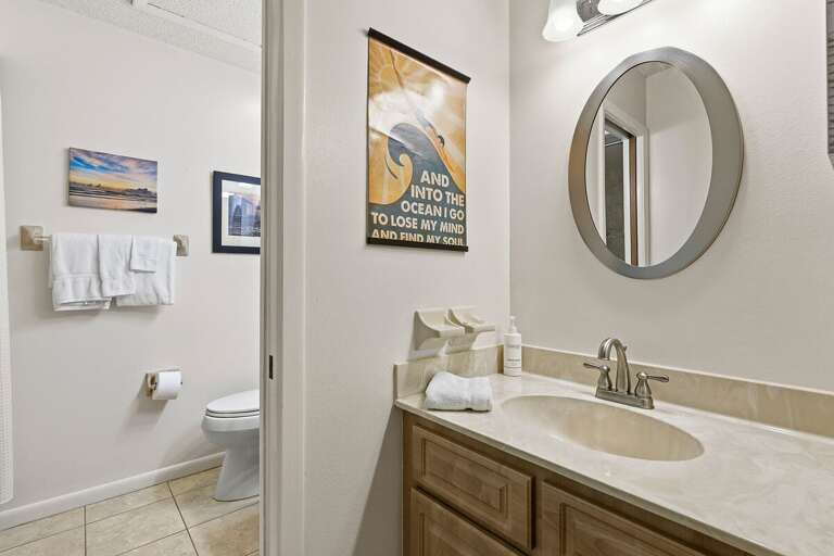 This bright, beach-inspired bathroom features a spacious vanity, modern fixtures, and fresh coastal