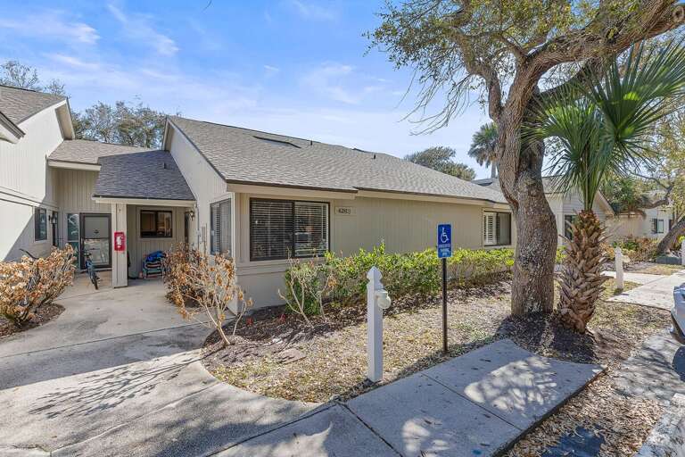 This charming coastal cottage offers convenient ground-level access, private entry, and lush