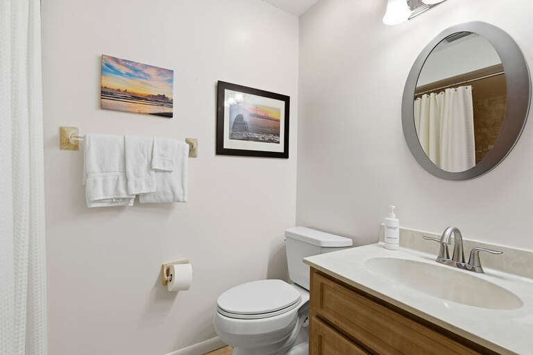 This clean, coastal-inspired bathroom features a spacious vanity, fresh towels, and modern fixtures.