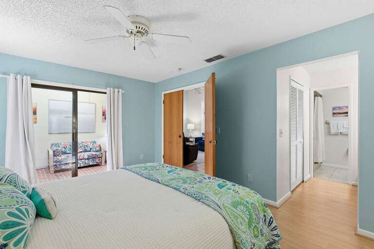 Enjoy comfort and privacy in this airy coastal bedroom featuring soft beach-inspired tones, patio