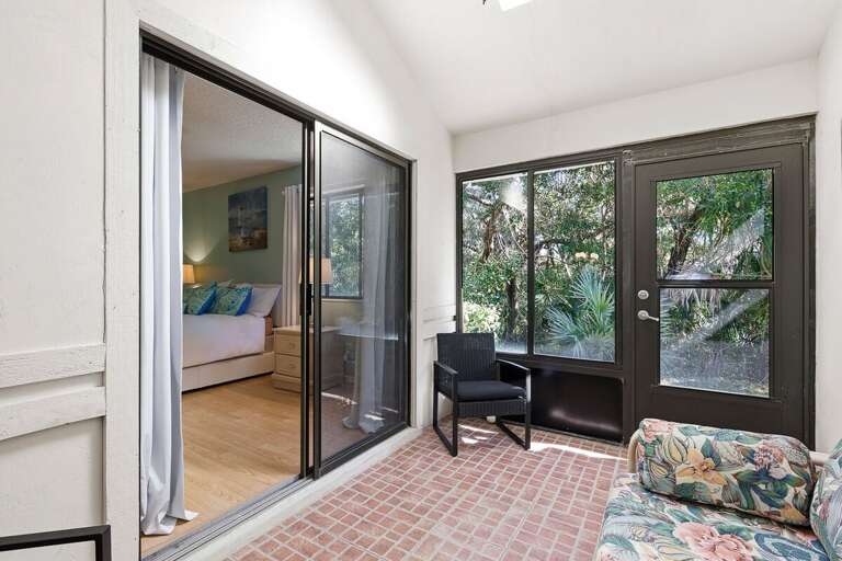 Enjoy tranquil garden views from this private patio with cozy seating and direct bedroom access. A