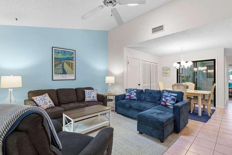 Relax in this airy, coastal-inspired living space featuring plush seating, vaulted ceilings, and an