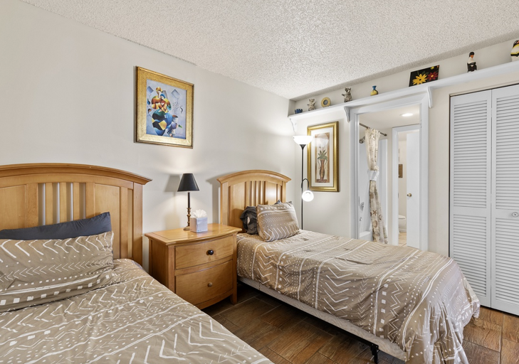 This cozy bedroom with twin beds is perfect for kids or guests. Conveniently located near the bathroom, it's a welcoming space to unwind and recharge during your beach stay.