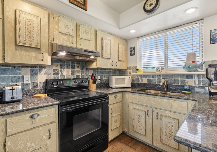 Prepare meals with ease in this fully stocked beach condo kitchen, featuring a smooth-top stove, microwave, toaster, and plenty of counter space—perfect for convenient dining during your beach stay.