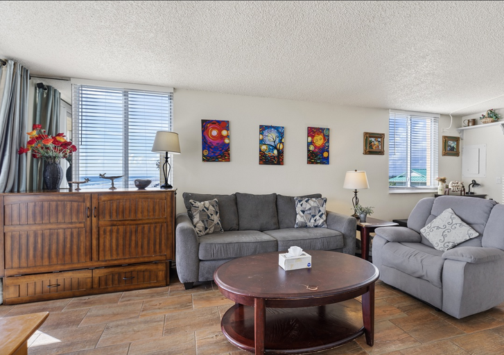 Unwind in this inviting living room featuring a plush sofa, cozy recliner, and bright coastal décor. Perfect for relaxing with family after a fun-filled day at the beach.