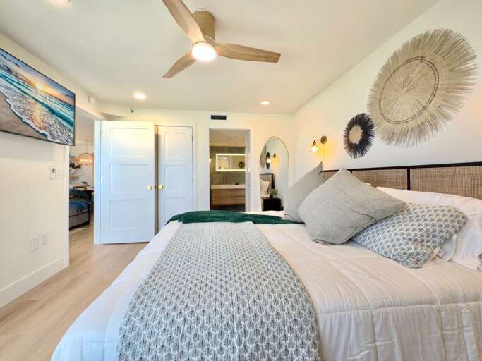 Relax in this beautifully designed bedroom featuring modern coastal décor, a plush bed, and serene tones—perfect for unwinding after a day of beachside adventures.