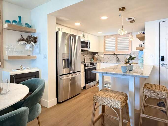 Whip up meals in this modern kitchen with stainless steel appliances, marble countertops, and cozy bar seating—perfect for enjoying breakfast before a relaxing day at the beach.