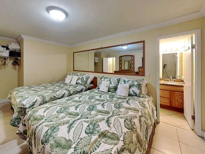 Rest easy after your beach adventures in this cozy bedroom featuring two plush beds, tropical décor, and a private bath. Perfect for families or friends on a seaside getaway. Rest easy after your beach adventures in this cozy bedroom featuring two plush beds, tropical décor, and a private bath. Perfect for families or friends on a seaside getaway.