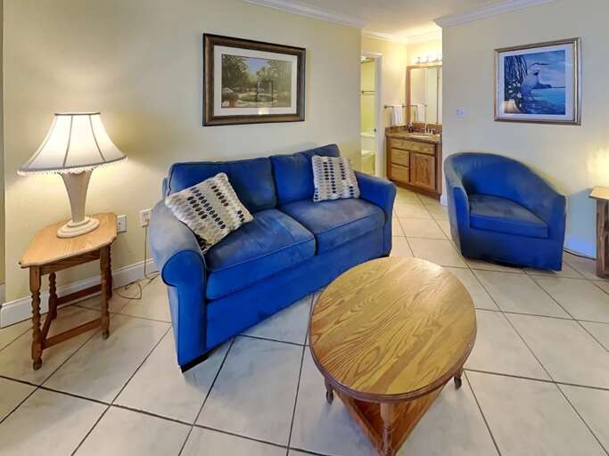 Unwind after a beach day in this cozy coastal living space, featuring a plush sofa, armchair, and warm lighting. A perfect spot to relax and recharge during your seaside getaway. Unwind after a beach day in this cozy coastal living space, featuring a plush sofa, armchair, and warm lighting. A perfect spot to relax and recharge during your seaside getaway.