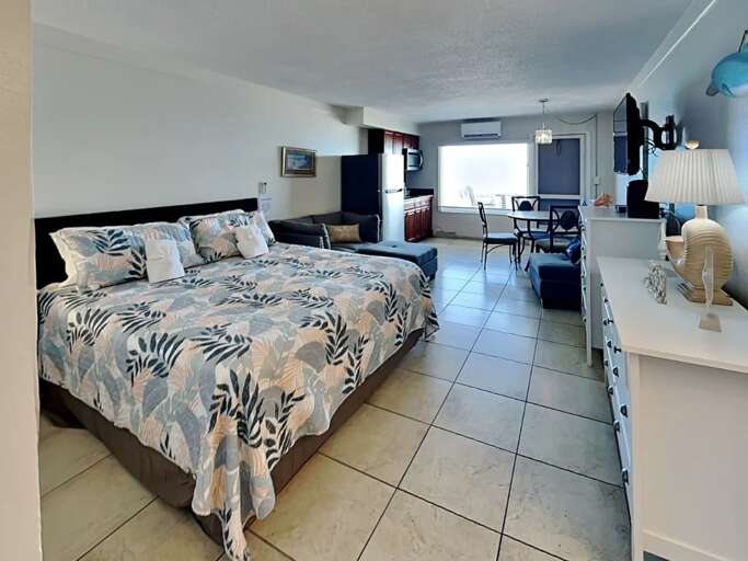 Stay in comfort with a king bed, cozy seating, and dining area in this bright studio. Large windows offer a peek at the ocean—perfect for a relaxing beach getaway. Stay in comfort with a king bed, cozy seating, and dining area in this bright studio. Large windows offer a peek at the ocean—perfect for a relaxing beach getaway.