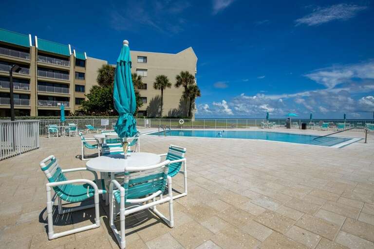 Enjoy a refreshing swim or lounge poolside with ocean views. This spacious deck offers plenty of seating, umbrellas, and sunshine—perfect for unwinding during your beach vacation stay.
