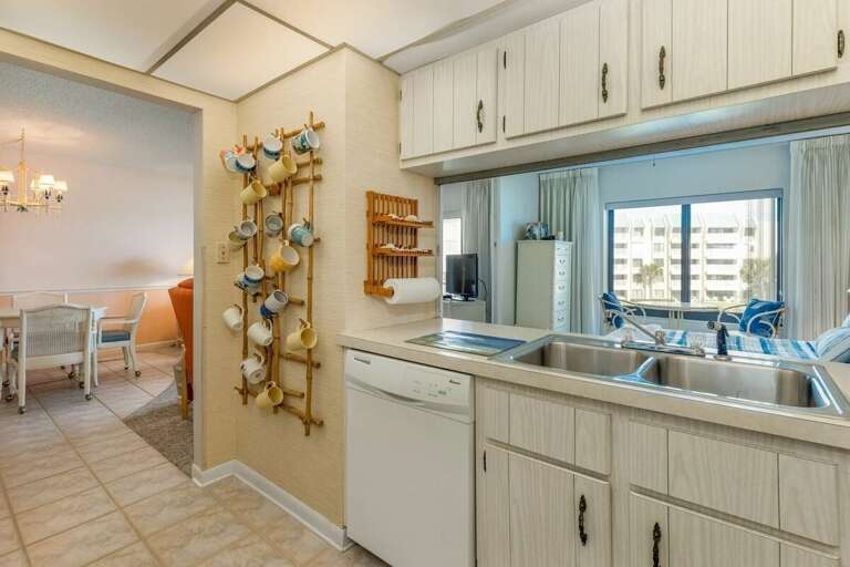 This charming beach stay kitchen features ample counter space, a double sink, and cozy coastal touches—perfect for preparing meals after a fun-filled day by the ocean. This charming beach stay kitchen features ample counter space, a double sink, and cozy coastal touches—perfect for preparing meals after a fun-filled day by the ocean.