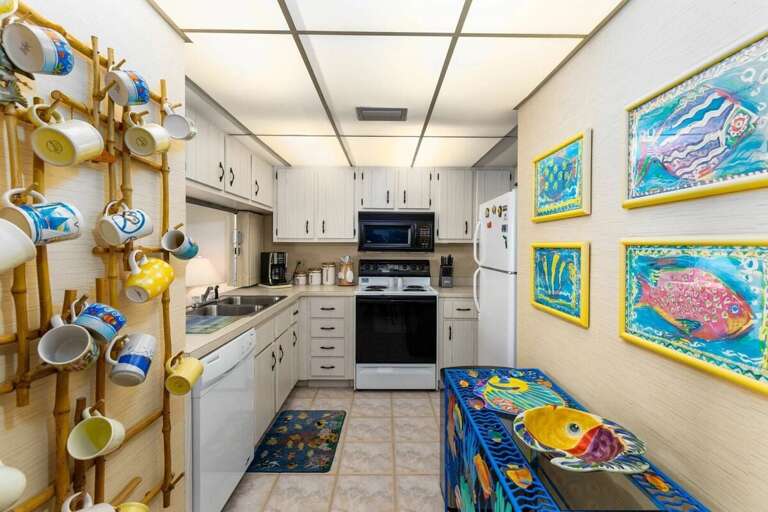 Cook up seaside favorites in this fully equipped beach stay kitchen, featuring colorful coastal art, ample counter space, and all the essentials for your oceanfront getaway. Cook up seaside favorites in this fully equipped beach stay kitchen, featuring colorful coastal art, ample counter space, and all the essentials for your oceanfront getaway.