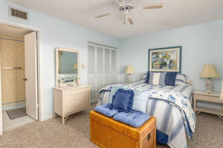 Enjoy a restful beach stay in this cozy bedroom featuring ocean-inspired bedding, soft blue décor, and convenient en-suite bath access for a relaxing seaside retreat. Enjoy a restful beach stay in this cozy bedroom featuring ocean-inspired bedding, soft blue décor, and convenient en-suite bath access for a relaxing seaside retreat.