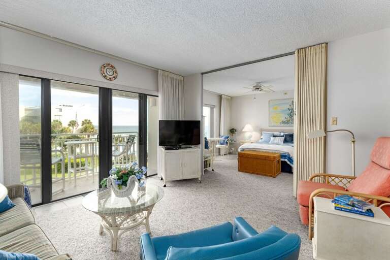 Enjoy your beach stay in this bright oceanview living space, featuring cozy seating, a flat-screen TV, and sliding doors opening to a private balcony with stunning seaside views. Enjoy your beach stay in this bright oceanview living space, featuring cozy seating, a flat-screen TV, and sliding doors opening to a private balcony with stunning seaside views.