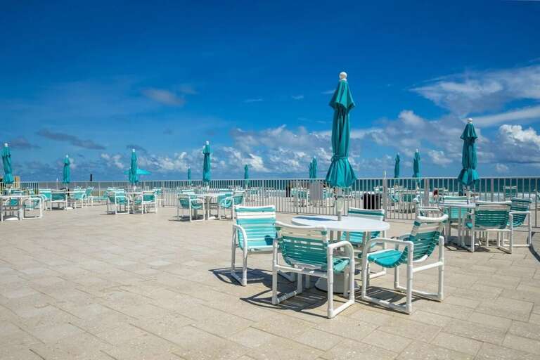 Relax during your beach stay on this spacious oceanview pool deck, offering plenty of shaded tables and chairs—perfect for soaking in the sea breeze and stunning coastal views. Relax during your beach stay on this spacious oceanview pool deck, offering plenty of shaded tables and chairs—perfect for soaking in the sea breeze and stunning coastal views.