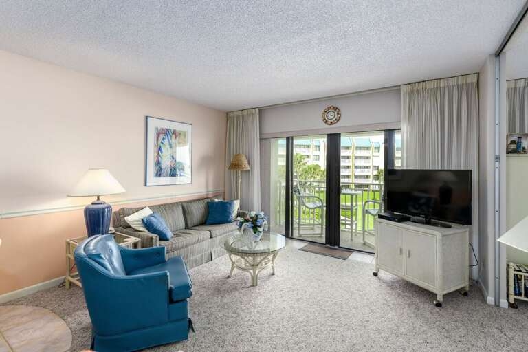 Unwind in this beach-inspired living room featuring plush seating, a flat-screen TV, and sliding doors to a private balcony—perfect for enjoying fresh ocean breezes during your seaside getaway. Unwind in this beach-inspired living room featuring plush seating, a flat-screen TV, and sliding doors to a private balcony—perfect for enjoying fresh ocean breezes during your seaside getaway.