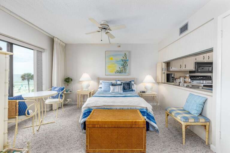 Wake up to breathtaking beach views in this oceanfront bedroom, featuring coastal décor, a cozy seating area, and convenient kitchenette access for the perfect beach stay retreat. Wake up to breathtaking beach views in this oceanfront bedroom, featuring coastal décor, a cozy seating area, and convenient kitchenette access for the perfect beach stay retreat.