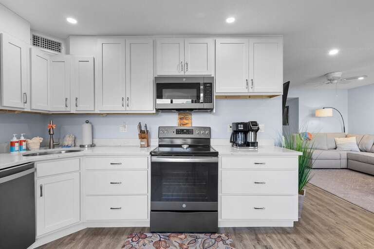 Cook up coastal favorites in this fully equipped beachside kitchen featuring stainless steel appliances, bright cabinetry, and plenty of counter space for family meals after a day in the sun.