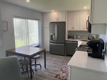 Cook and dine with ease in this fully equipped modern kitchen. Featuring stainless steel appliances and a cozy dining nook, it's the perfect setup for your beach stay meals and gatherings.