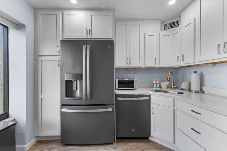 This fully equipped beach condo kitchen features sleek stainless appliances, spacious counters, and coastal-inspired charm—perfect for preparing seaside meals during your coastal getaway.