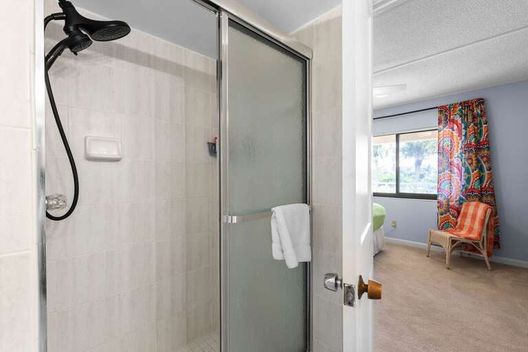 Rinse off the sand and salt in this bright, tiled walk-in shower. Conveniently located off the bedroom, it's perfect for a quick refresh after a sunny day at the beach.