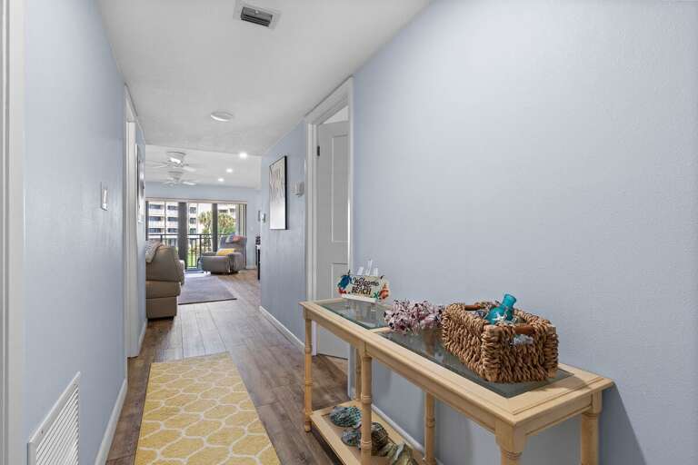 Step into your relaxing beach getaway through this inviting coastal hallway featuring seaside décor and warm tones that set the mood for your oceanfront stay.