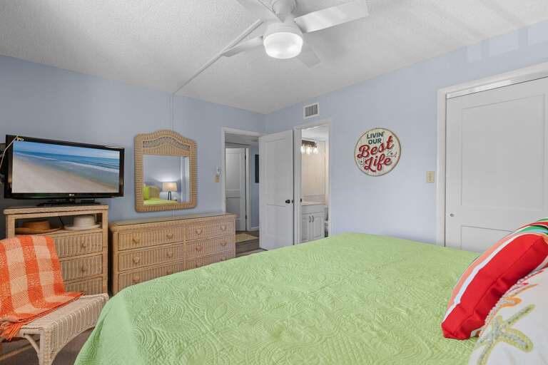 Unwind in this cheerful beachside bedroom featuring tropical décor, a flat-screen TV, and direct access to a private bath—ideal for ending your seaside adventures in comfort and style.
