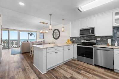 Bright beachfront condo with a modern kitchen, ocean views, and open dining space. Enjoy seaside Bright beachfront condo with a modern kitchen, ocean views, and open dining space. Enjoy seaside
