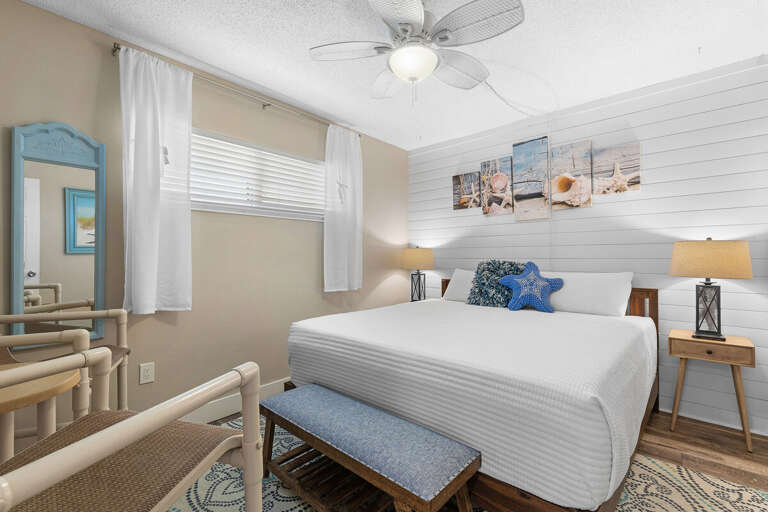 Charming beach-themed bedroom featuring cozy bedding, coastal artwork, and serene tones—perfect for relaxing after a sunny day by the ocean.