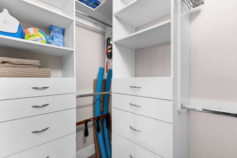 Convenient storage space stocked with beach essentials like towels, pool noodles, and gear—perfect for organizing everything you need for your fun-filled coastal stay.