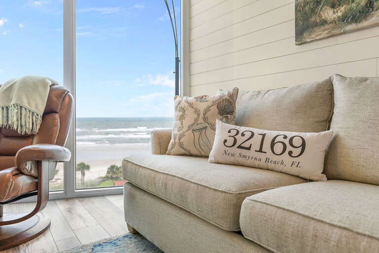 Relax in this inviting oceanfront living space featuring coastal décor, comfy seating, and panoramic beach views—perfect for unwinding after a sunny day by the sea.
