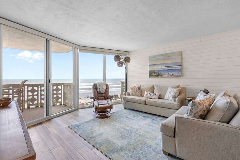 Unwind in this bright oceanfront living room featuring panoramic beach views, cozy coastal décor, and plush seating—perfect for relaxing after a sun-filled day on the shore. Unwind in this bright oceanfront living room featuring panoramic beach views, cozy coastal décor, and plush seating—perfect for relaxing after a sun-filled day on the shore.