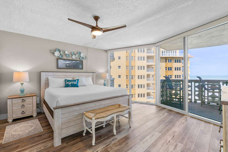 Wake up to stunning beach views in this serene coastal bedroom featuring a king bed, natural light, and private balcony access—perfect for a peaceful seaside escape.