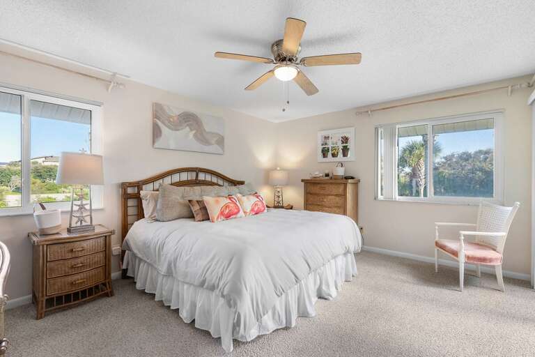 Drift into relaxation in this bright master bedroom featuring beach-inspired décor, plush bedding, and serene palm views — the perfect retreat for your seaside escape.