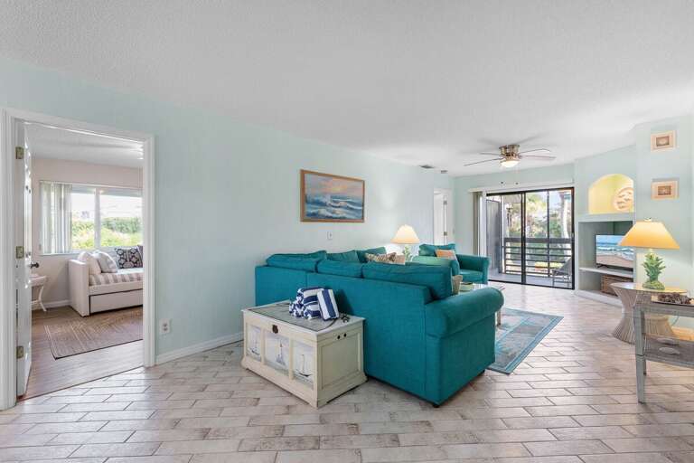 Gather and relax in this bright, beach-inspired living space featuring ocean décor, comfy seating, and easy access to the patio — perfect for unwinding after a day of sun and surf.