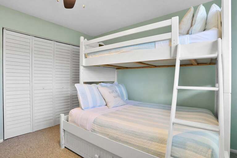 Simple Sleeping Space With Stacked Beds Beside Shuttered Storage